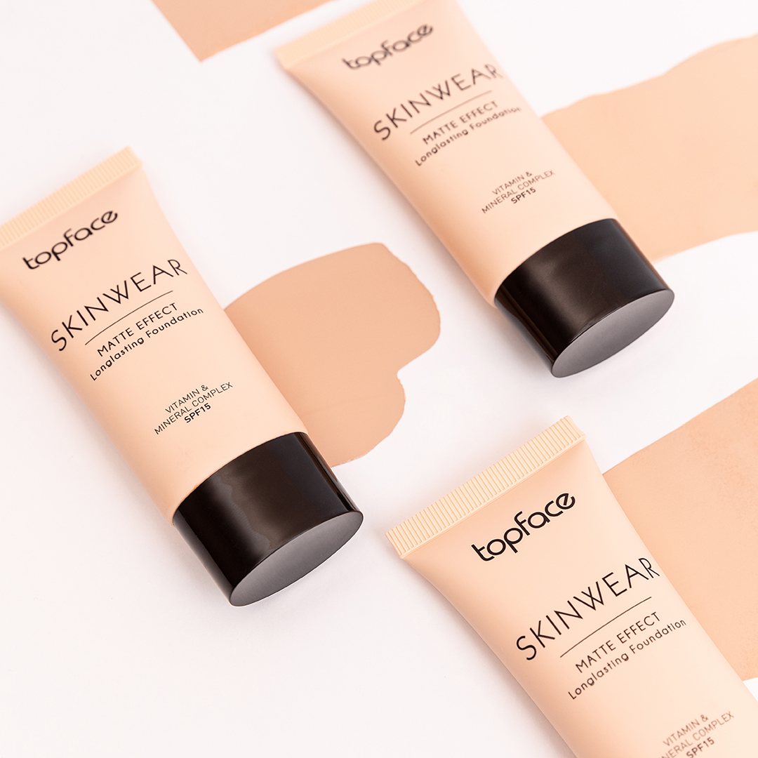Three matte foundation tubes with black caps and beige swatches on white